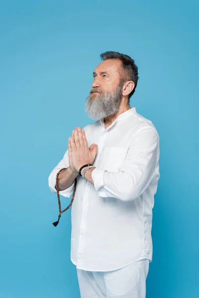 Szakállas Spirituális Edző Malagyöngyökkel Meditálva Imádkozó Kezekkel Elszigetelve Kéktől — Stock Fotó