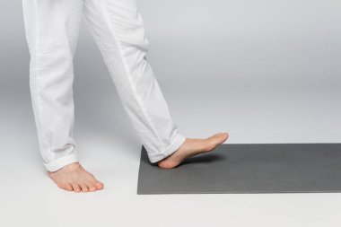 Çıplak ayaklı guru Grinin üstünde yoga minderine basıyor. 