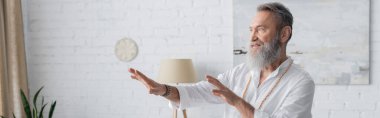Sakallı usta guru, uzanmış ellerle meditasyon yaparken yüzünü çeviriyor.