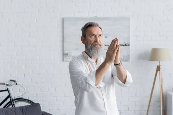 Konzentrierter Guru Mann Schaut Weg Während Mit Betenden Händen Meditiert — Stockfoto