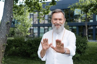 pozitif ve sakallı ruhani guru parktaki kameraya bakıyor.