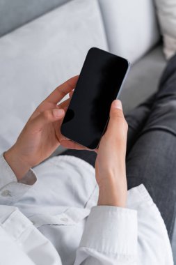 Beyaz ekranlı akıllı telefon tutan Afro-Amerikan kadın manzarası.