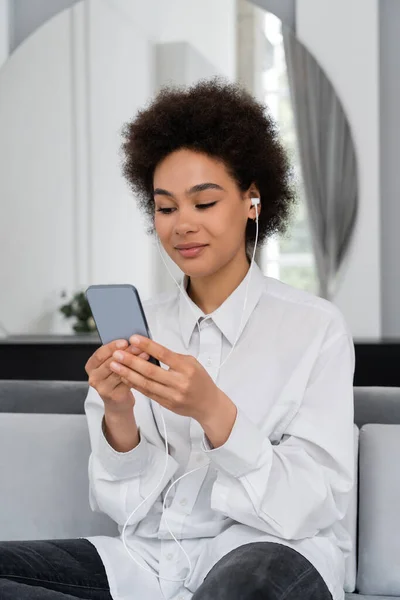 Pleased African American Woman Listening Music Wired Earphones Using Smartphone — Stockfoto