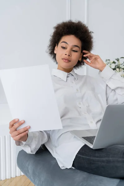 Mujer Afroamericana Mirando Papel Blanco Mientras Usa Computadora Portátil Casa — Foto de Stock