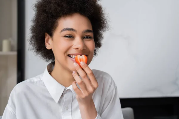 Happy African American Woman Eating Fresh Strawberry Looking Camera — Stockfoto