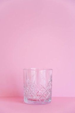 Pembe arkaplanda boş ve şeffaf bir cam var. 
