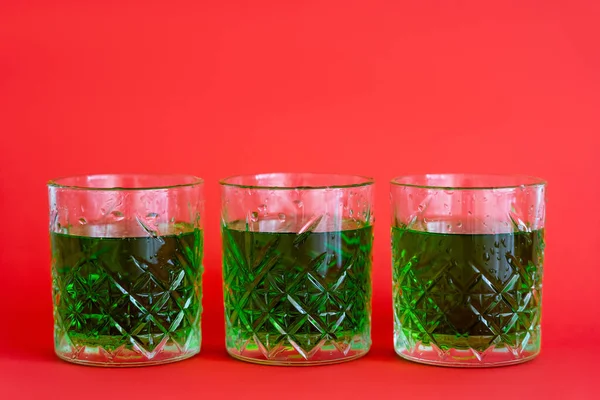 Bebida Alcohólica Verde Tres Vasos Facetados Con Gotas Agua Rojo — Foto de Stock
