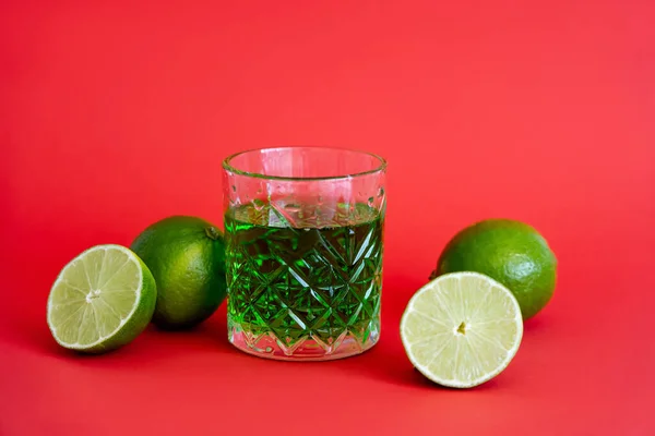 Bevanda Alcolica Verde Vetro Sfaccettato Vicino Lime Acide Rosso — Foto Stock