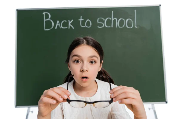 Scioccato Scolaro Con Occhiali Vicino Lavagna Sfocata Con Iscrizione Scuola — Foto Stock