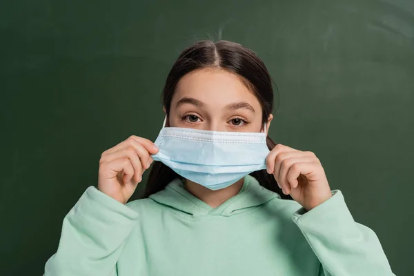 Brunette Schoolkid Wearing Medical Mask Chalkboard Background — Stock Photo, Image
