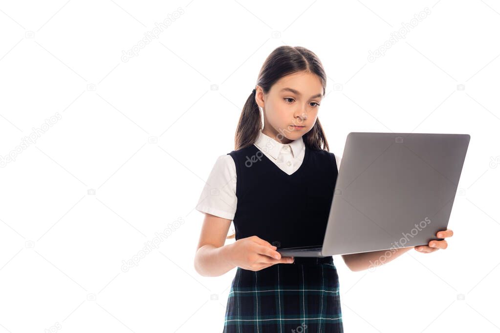 Brunette schoolkid holding laptop isolated on white 