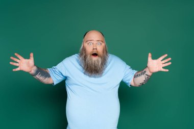 astonished bearded man with open mouth showing wow gesture isolated on green