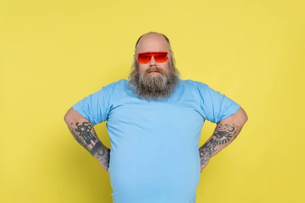 Overweight Bearded Man Red Sunglasses Standing Akimbo Isolated Yellow — Stock Photo, Image