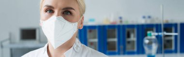 Scientist in protective mask looking at camera in laboratory, banner 