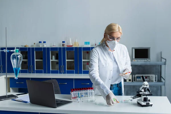 Scientist Protective Mask Holding Syringes Test Tubes Laptop Lab — Stockfoto