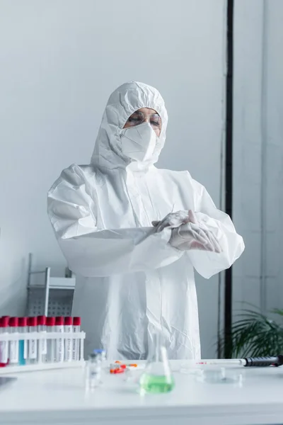 Scientist Protective Suit Mask Standing Blurred Test Tubes Lab — Stock Photo, Image