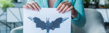 Cropped view of psychologist holding Rorschach test in consulting room, banner 