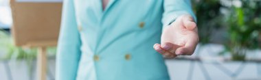 Cropped view of blurred psychologist outstretching hand in consulting room, banner 