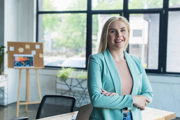 Cheerful Blonde Psychologist Looking Camera Blurred Laptop Consulting Room — стоковое фото