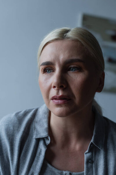 portrait of upset blonde woman with menopause looking away