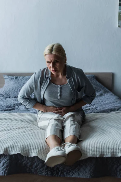 Mujer Rubia Molesta Con Menopausia Que Sufre Dolor Abdominal Dormitorio —  Fotos de Stock