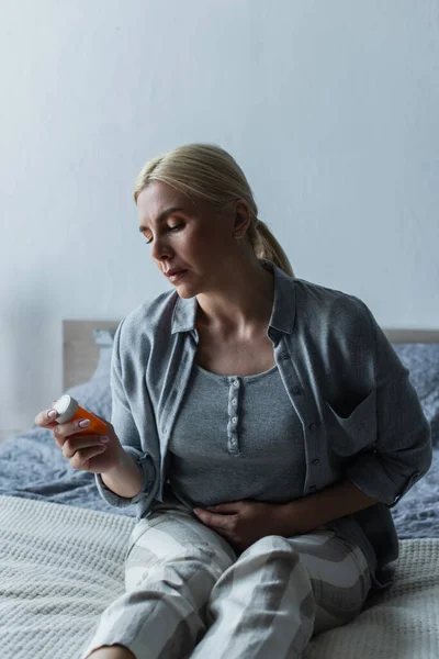 Depressed Blonde Woman Menopause Holding Bottle Pills Sitting Bed — Fotografia de Stock