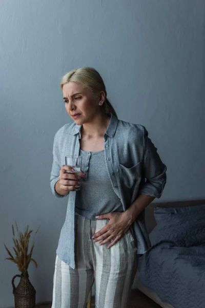 Vrouw Met Menopauze Die Een Glas Water Vasthoudt Terwijl Buikpijn — Stockfoto