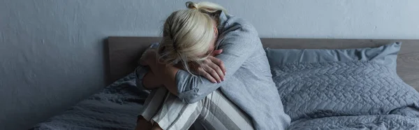 Blonde Woman Covering Face Hugging Knees Bed While Feeling Pain — Fotografie, imagine de stoc