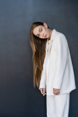 Siyah arka plandaki kameraya bakan uzun saçlı, güzel bir kadın.