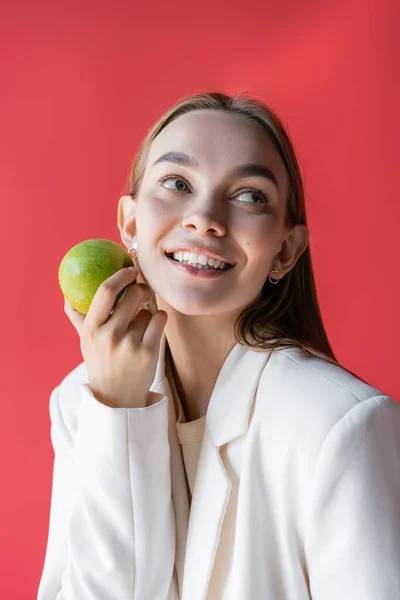 Smiling Woman Fresh Ripe Apple Looking Away Isolated Carmine Pink — Zdjęcie stockowe