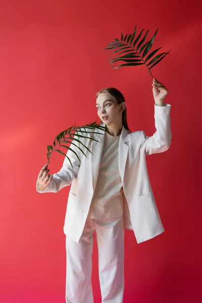 Jonge Vrouw Witte Kleren Poseren Met Groene Tropische Bladeren Karmozijn — Stockfoto