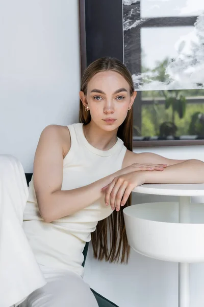 Trendy Woman White Tank Top Leaning Coffee Table Window — Stockfoto