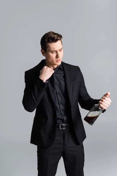 Frustrated Man Black Suit Holding Bottle Whiskey Isolated Grey — 图库照片