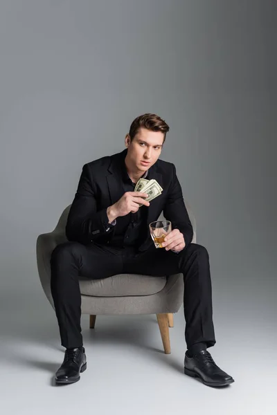 Full Length Man Black Suit Sitting Armchair Money Whiskey Grey — Foto de Stock