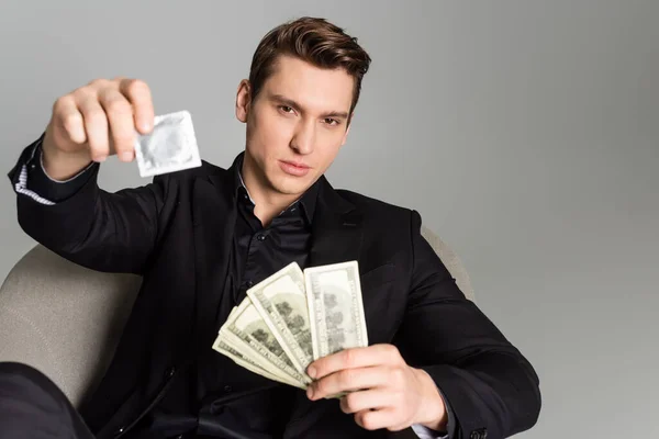 Man Black Formal Wear Holding Condom Dollar Banknotes Blurred Foreground — Foto de Stock