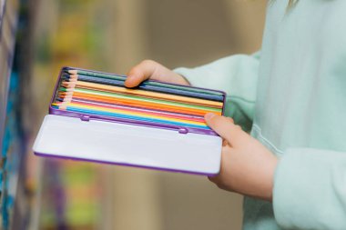 Yeni renkli kalem seti tutan çocukların kısmi görünümü