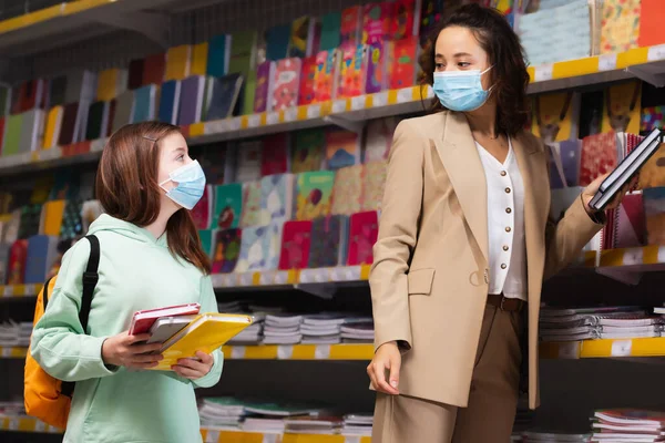 Mother Daughter Medical Masks Looking Each Other While Holding Copybooks — Fotografia de Stock