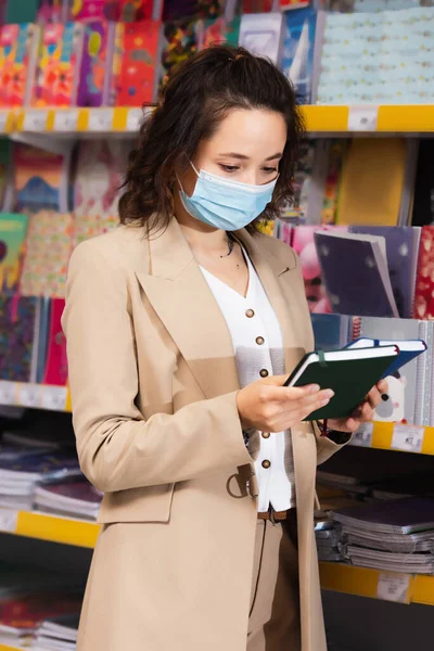 Brunette Woman Medical Mask Choosing Notepads Stationery Store — Fotografia de Stock