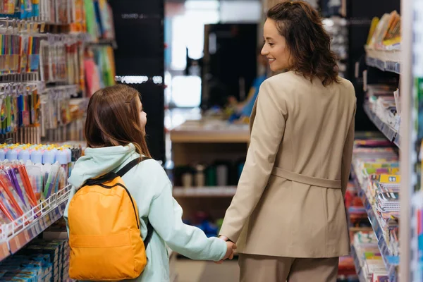 Back View Smiling Woman Girl Backpack Holding Hands Stationery Store — 스톡 사진