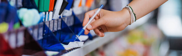cropped view of woman in beaded bracelets trying ball pen in stationery store, banner