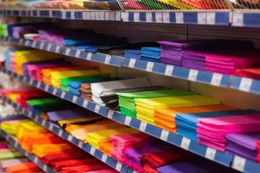 rack with multicolored plastic files and folders in stationery store