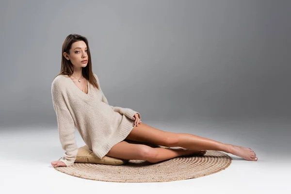 Pretty Woman Warm Sweater Naked Legs Sitting Rug Grey Background — Stockfoto