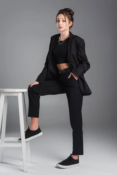 Young Brunette Woman Posing Hand Pocket Black Trousers White Stool — 스톡 사진