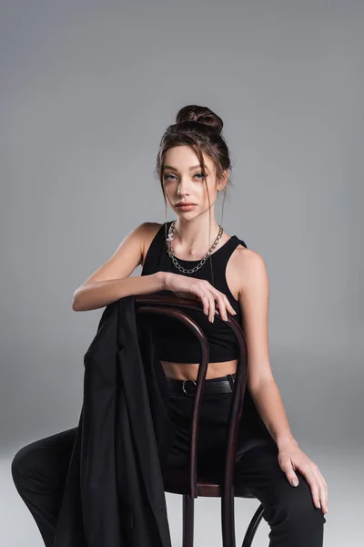 Young Woman Black Crop Top Silver Necklace Sitting Chair Jacket — стоковое фото