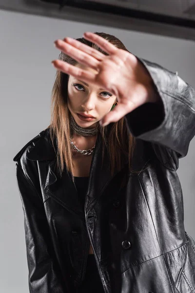 Fashionable Woman Black Leather Coat Looking Camera Gesturing Grey Background — 图库照片