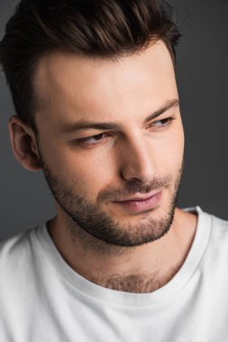 Portrait of young brunette man in t-shirt isolated on grey 