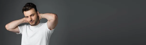 Young Man White Shirt Touching Neck Looking Camera Isolated Grey — Zdjęcie stockowe