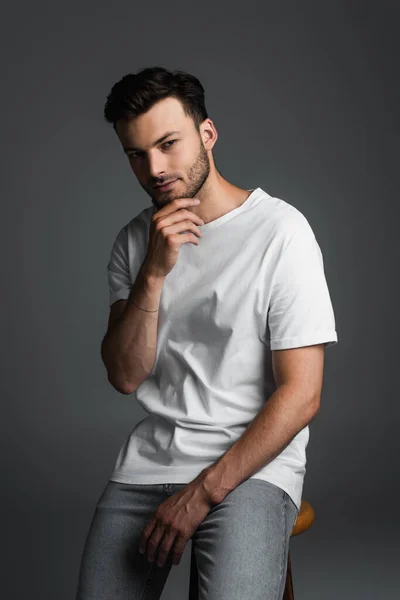 Brunette Man Jeans White Shirt Touching Chin While Sitting Chair — Stockfoto