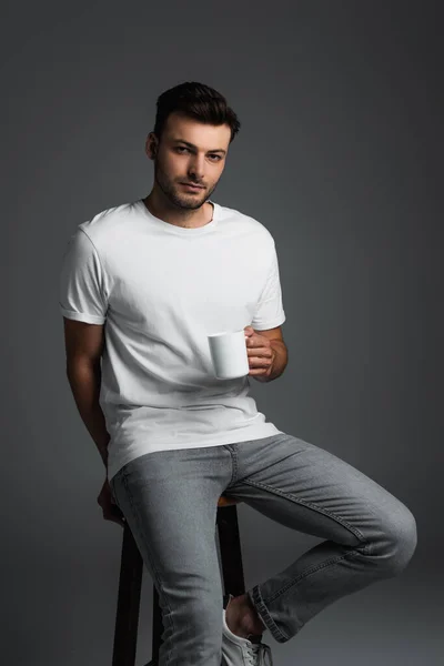 Young Man White Shirt Jeans Holding Coffee Cup While Sitting — Foto de Stock