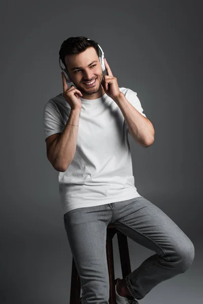 Smiling Man Wireless Headphones Sitting Chair Isolated Grey — Fotografia de Stock